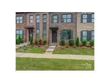 Charming brick townhome featuring well-maintained landscaping and a welcoming entryway, providing an inviting curb appeal at 416 Linestowe Dr, Belmont, NC 28012