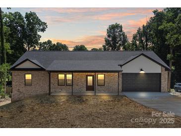 Charming brick home featuring an attached garage, covered front porch and neutral trim details at 5526 Brookwood Ln, Hickory, NC 28602