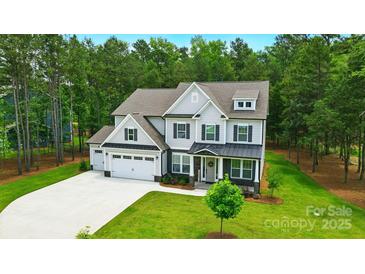 Beautiful two-story home with a three-car garage and well-manicured lawn at 7818 Russell Rd, Indian Trail, NC 28079