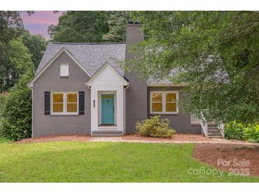 Charming gray brick home with a quaint teal front door and well-manicured lawn at 1106 S South St, Gastonia, NC 28052