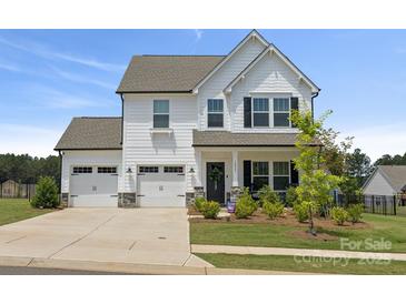 Charming two-story home featuring a three-car garage and beautifully landscaped front yard at 12001 Sam Snead Ct, Lancaster, SC 29720