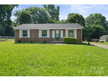 Charming brick home with well-manicured lawn and classic white shutters at 1218 Milan Rd, Charlotte, NC 28216