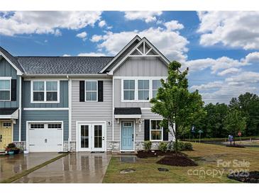 Charming townhome featuring a light blue front door, manicured lawn, and stone accents at 124 Kristin View Ln # Townhome A, Troutman, NC 28166
