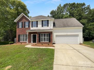 Charming two-story home featuring a brick and vinyl facade, attached two car garage, and a well-maintained lawn at 1523 Merrie Meadow Ct, Rock Hill, SC 29732