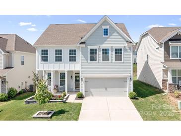 Charming two-story home with light blue siding, white trim, and a welcoming two-car garage at 3038 Burnello Ct, Iron Station, NC 28080