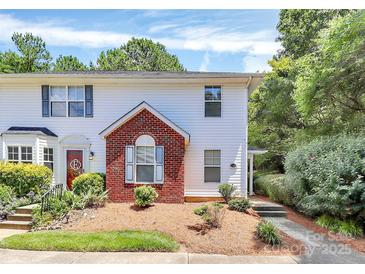 Charming two-story townhome featuring white siding, a brick facade, and a well-manicured front yard with lush landscaping at 4263 Melrose Club Dr, Matthews, NC 28105