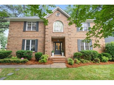 Charming brick two-story home featuring a landscaped front yard, black shutters, and classic architectural details at 4808 Cobble Glen Way, Charlotte, NC 28269