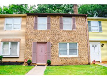Charming brick townhome with muted pink shutters, well-manicured lawn, and inviting front entrance at 7526 Holly Grove Ct, Charlotte, NC 28227