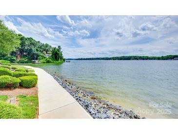 Picturesque waterfront view with a paved path, lush greenery, and stunning lake views, perfect for serene living at 14053 Queens Harbor Rd, Charlotte, NC 28278