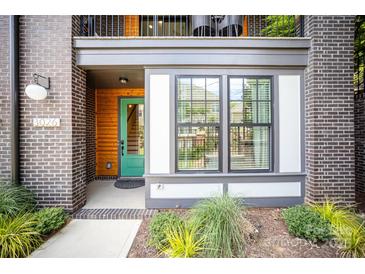 Inviting entryway with modern brick, stylish trim, a green door, and large window at 3026 Kalex Ct, Charlotte, NC 28204