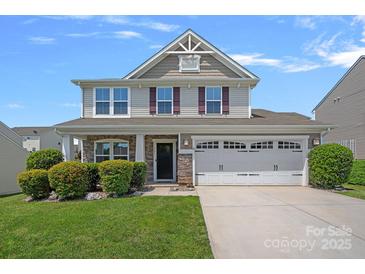 Charming two-story home with a two-car garage, landscaped yard, and inviting covered front porch at 321 Almora Loop, Mooresville, NC 28115