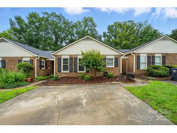 Charming brick home with manicured landscaping and a concrete driveway at 656 Ne Camrose Ne Cir, Concord, NC 28025
