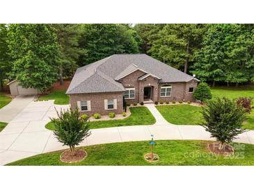 Beautiful brick home with well-manicured lawn, curved driveway, and lovely landscaping at 106 Pier Point Dr, Stony Point, NC 28678