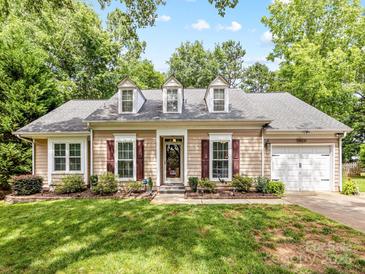 Charming one-story home boasts beautiful landscaping, dormer windows, and an attached two car garage at 13600 Seastone Ln, Pineville, NC 28134