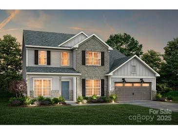 New two-story home featuring a stone and vinyl facade, a two-car garage, and a well-manicured lawn at 13908 Penbury Rd # 394, Charlotte, NC 28278