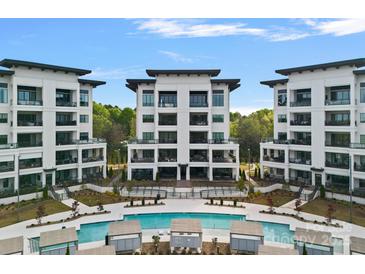 Stunning view of a modern condo complex with a sparkling pool and lush greenery at 19329 Watermark Dr # 422, Cornelius, NC 28031