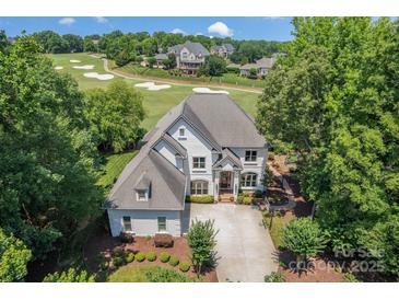 Stunning exterior elevation of home overlooking a golf course and showcases the well-maintained landscape at 1032 Spyglass Ln, Waxhaw, NC 28173