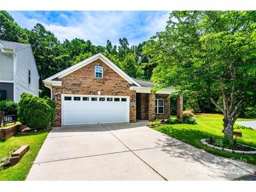 Charming brick home with a two-car garage, manicured lawn, and beautiful landscaping for great curb appeal at 141 Aberdeen Dr, Troutman, NC 28166