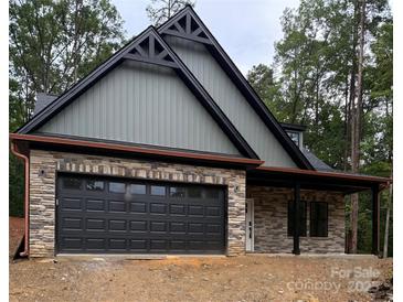 Beautiful new home features stone and siding, with a two-car garage and covered porch at 1923 Fairfield Rd, Mount Gilead, NC 27306