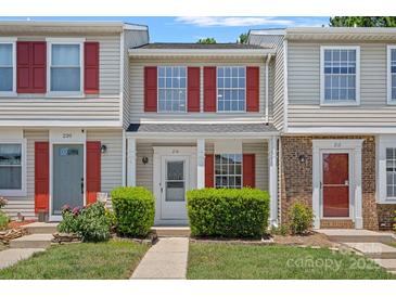 Charming townhome with a well-manicured front yard and inviting entrance. Features red shutters at 218 Water Oak Dr, Pineville, NC 28134