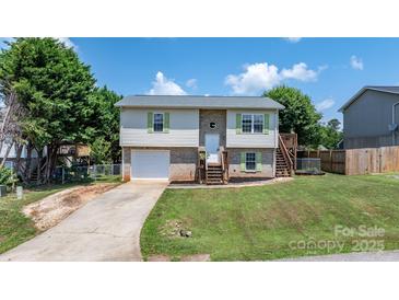 Charming split-level home with brick and vinyl siding, complemented by green shutters and a well-manicured lawn at 23 Redwood Ct, Alexander, NC 28601