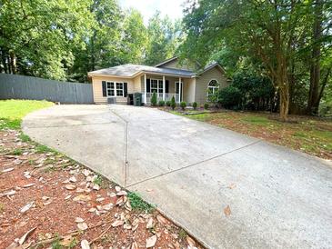 Charming one-story home featuring a spacious driveway and well-maintained landscaping at 3051 Dairy Farm Dr, Monroe, NC 28110