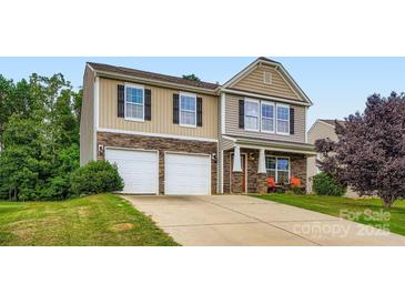 Charming two-story home with a manicured lawn and a two-car garage showcasing great curb appeal at 4151 Granite St, Midland, NC 28107