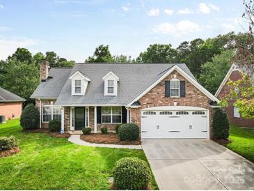 Charming brick home with well-manicured lawn, dormer windows, and a two-car garage at 5707 Sustar Dr, Monroe, NC 28110