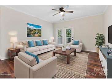 Bright living room with wood floors, ceiling fan, and access to a balcony or patio at 17136 Red Feather Dr, Charlotte, NC 28277