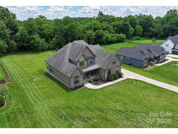 Gorgeous gray home with a large lawn and a covered front porch perfect for relaxing at 174 Bellingshire Dr, Mt Ulla, NC 28125