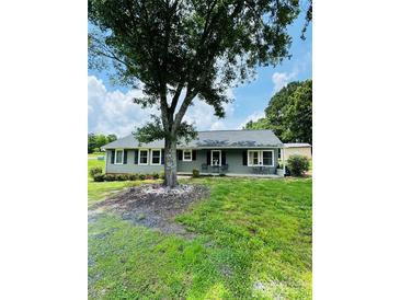 Charming ranch-style home with a large front yard and mature tree providing shade at 24007 Old Aquadale Rd, Albemarle, NC 28001