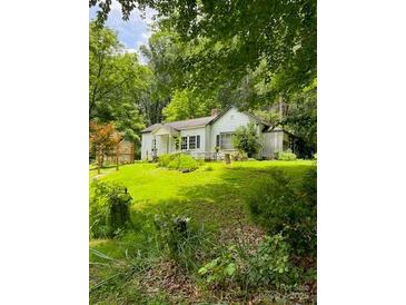 Charming cottage-style home with a well-maintained lawn and mature trees providing ample shade and privacy at 3275 Love Rd, Claremont, NC 28610