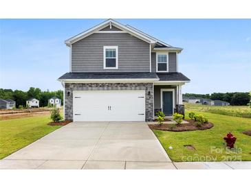 Two-story home featuring gray siding, stone accents, an attached two-car garage, and a well-maintained front lawn at 415 Luna Ln, Shelby, NC 28152