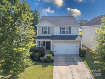 Charming two-story home with a well-maintained lawn and a two car garage at 6945 Agava Ln, Charlotte, NC 28215