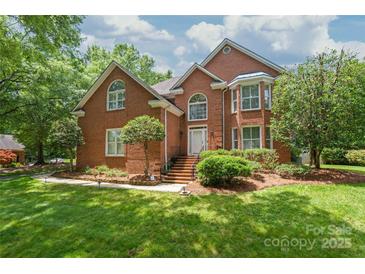 Beautiful brick home with manicured lawn, mature trees, and inviting front entrance at 7301 Leharne Dr, Charlotte, NC 28270