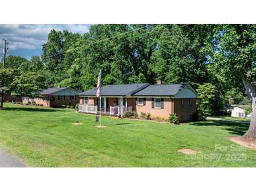 Charming brick home featuring a well-manicured lawn and inviting front porch at 135 Burton Hills Cir, Gastonia, NC 28054
