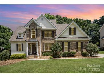 Charming brick and siding home with a well-manicured lawn and a picturesque sunset sky. A beautiful two-story Gathering home at 1846 Sam Smith Rd, Fort Mill, SC 29708