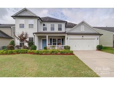 Charming two-story home with a manicured lawn, a blue front door, and an attached two-car garage at 3009 Palm Dr, Fort Mill, SC 29715