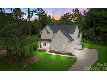 Beautiful two-story home featuring lush green lawn, manicured landscaping, and a long, private driveway at 3222 Player Ct, Salisbury, NC 28144