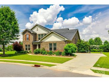Charming brick two-story home with a lush green lawn and well-maintained landscaping on a sunny day at 4220 Thames Cir, Fort Mill, SC 29715