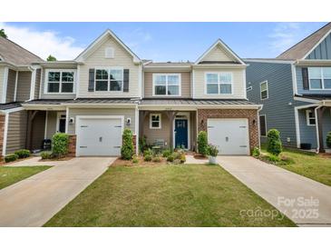 Charming townhome with well-maintained lawn, blue door, and attached garage at 8042 Saluda Dr, Charlotte, NC 28269
