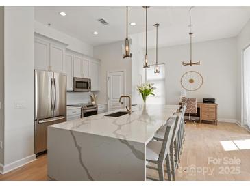 Bright kitchen with large island, stainless steel appliances, and stylish pendant lighting at 1315 East Blvd # 225, Charlotte, NC 28203