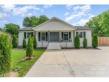 Charming white brick home featuring a covered porch and well-manicured landscaping at 157 Downey Lake Rd, Dallas, NC 28034