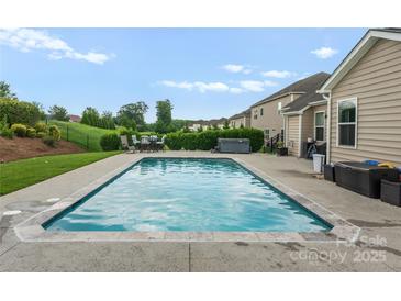 Backyard with a private pool, patio, and manicured landscaping, perfect for outdoor entertaining at 163 Sassafras Rd, Mooresville, NC 28115