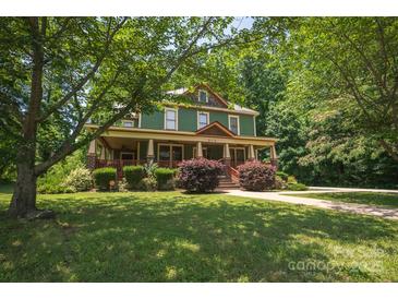 Charming two-story home featuring a welcoming front porch and lush landscaping at 215 W Eastway Drive Dr, Charlotte, NC 28213