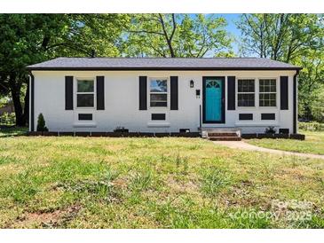 Charming painted brick home featuring a vibrant blue front door and a well-maintained lawn at 2515 Danforth Ln, Charlotte, NC 28208