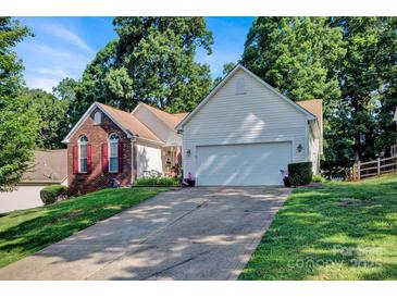 Inviting home with a brick facade, two-car garage, mature trees and a long driveway at 2620 Yarrow Rd, Charlotte, NC 28213