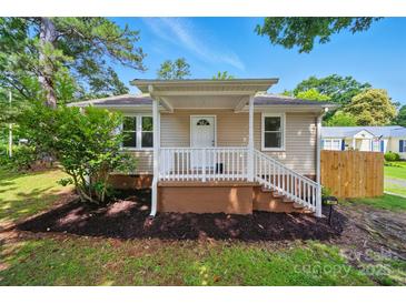 Charming single-story home featuring a cozy front porch and well-manicured lawn with mature trees at 407 Cummings St, Rock Hill, SC 29730
