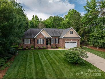 Charming brick home featuring a well-manicured lawn and an attached two-car garage at 7988 Golf Course N Dr, Denver, NC 28037
