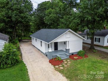 Charming house with a landscaped front yard, gravel driveway and gray painted porch at 1210 Cloninger Ave, Gastonia, NC 28052